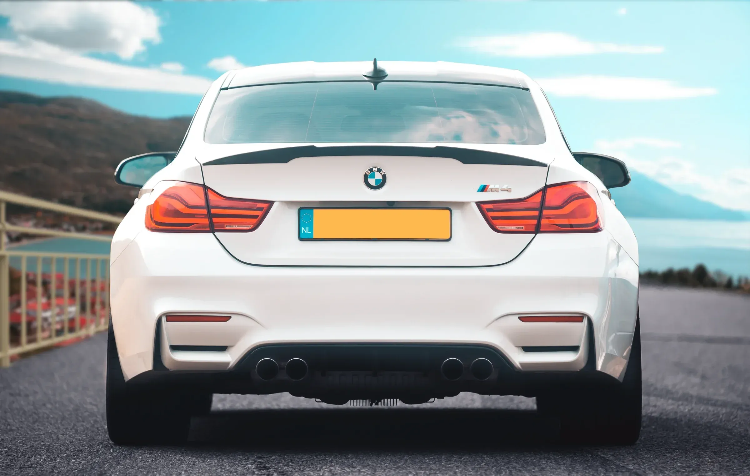 White BMW M4 graded with cool slate-blue tones against a city backdrop